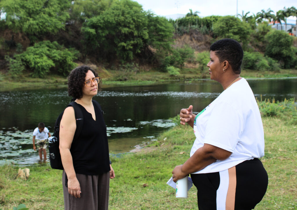 À beira do Rio de Contas, Jeiziane mostra a realidade dos atingidos de Jequié para pesquisadora. Foto: Marcos Souza / MAB