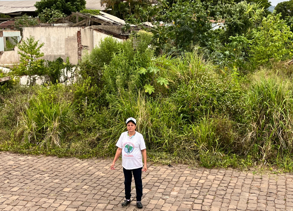 Na Rua Campos Sales, em Arroio do Meio, Odete mostra o terreno onde ficava a casa em que morou mais de 20 anos, já tomado pela vegetação. Foto: Debora Moraes / MAB