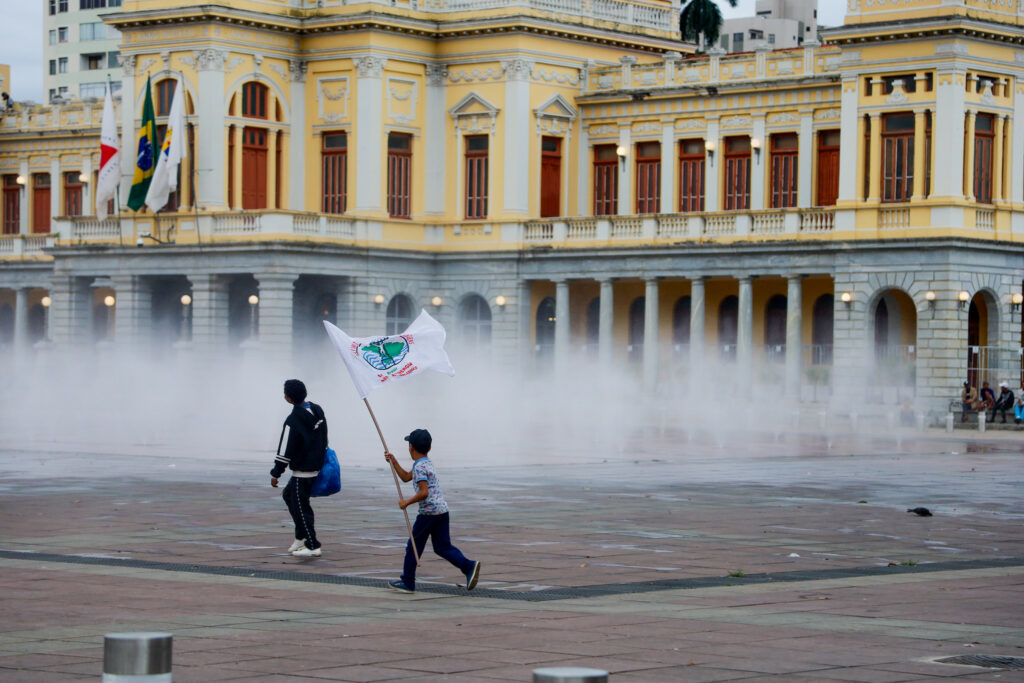 Criança brinca com bandeira do MAB durante ato na Praça da Estação, em Belo Horizonte (MG). Maio de 2025. Foto: Nívea Magno / MAB