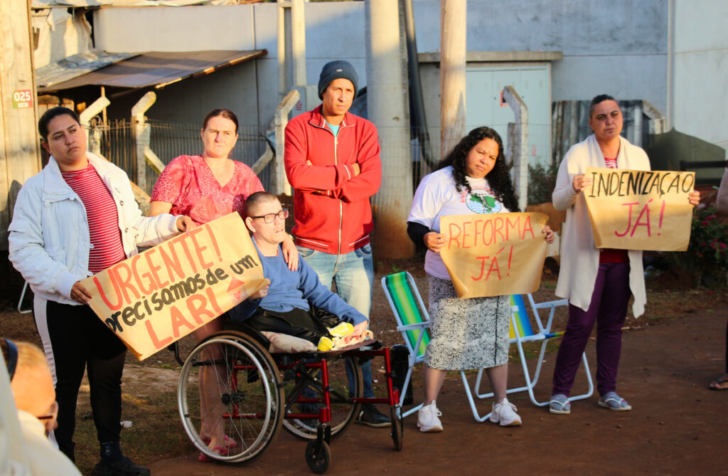Cristiano, de vermelho, denuncia a realidade dos moradores das casas provisórias de Estrela. Foto: Victória Holzbach / MAB