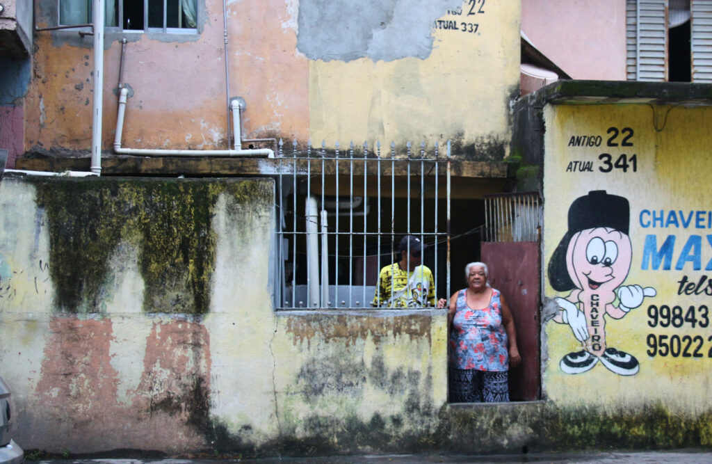 Dona Maria em frente à casa atingida frequentemente pelas cheias do córrego do Lajeado, no Jardim Pantanal, zona leste da capital. Foto: Victória Holzbach / MAB