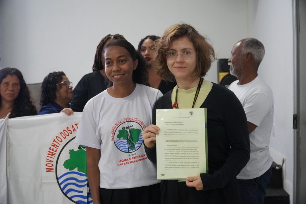 Jéssica Silva, integrante do MAB, entrega a carta que reivindica a regulamentação da PNAB para Zilda Manuela Onofri Patente, da Secretaria-Geral da Presidência da República. Foto: Thiago Matos / AEDAS