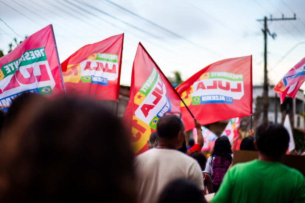 Muitas pessoas caminham e balançam bandeiras vermelhas com o nome de Lula durante ato no Espírito Santo. Foto: Comunicação MAB ES