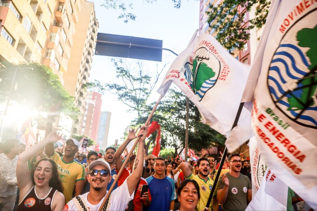 Pessoas em caminhada durante ato nas ruas de Brasília. Algumas bandeiras do MAB aparecem na imagem. Foto: Comunicação MAB DF